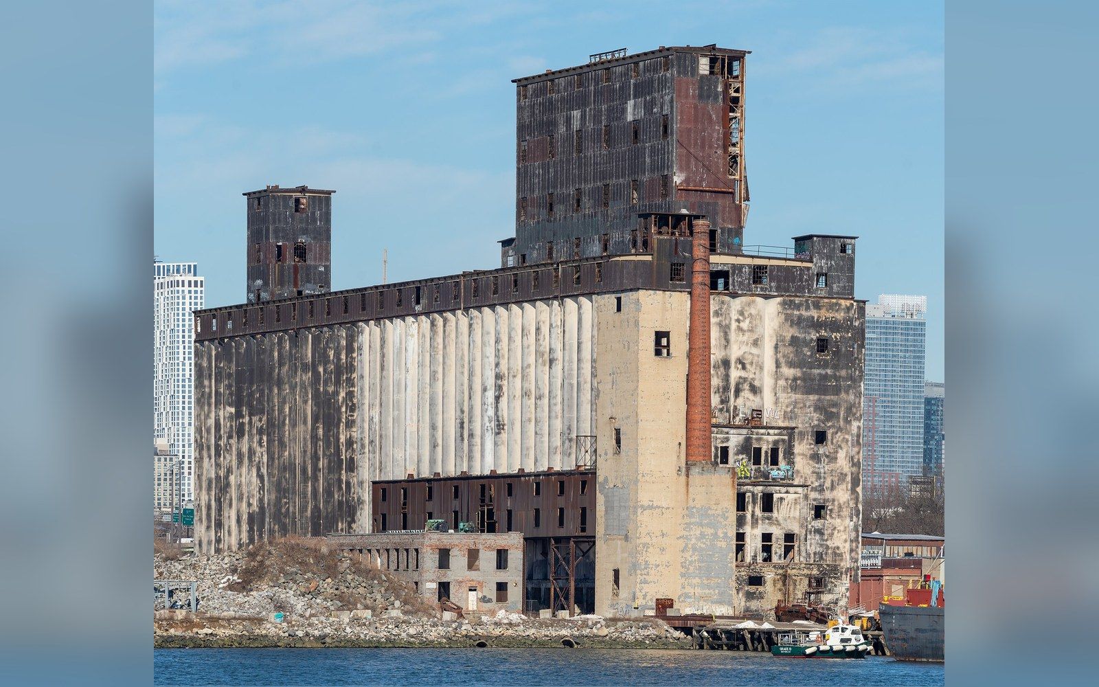 A vast concrete grain elevator on a derelict waterfront